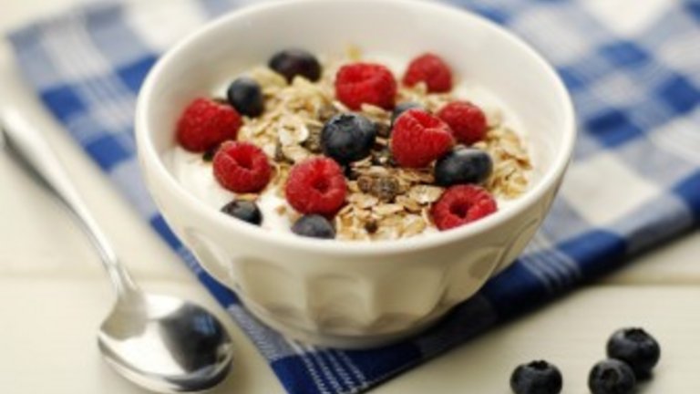 Muesli bowl with oatflakes,raisins,fruits and yoghurt. Selective focus.