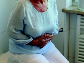 woman holding her stomach beccause she is feeling sick